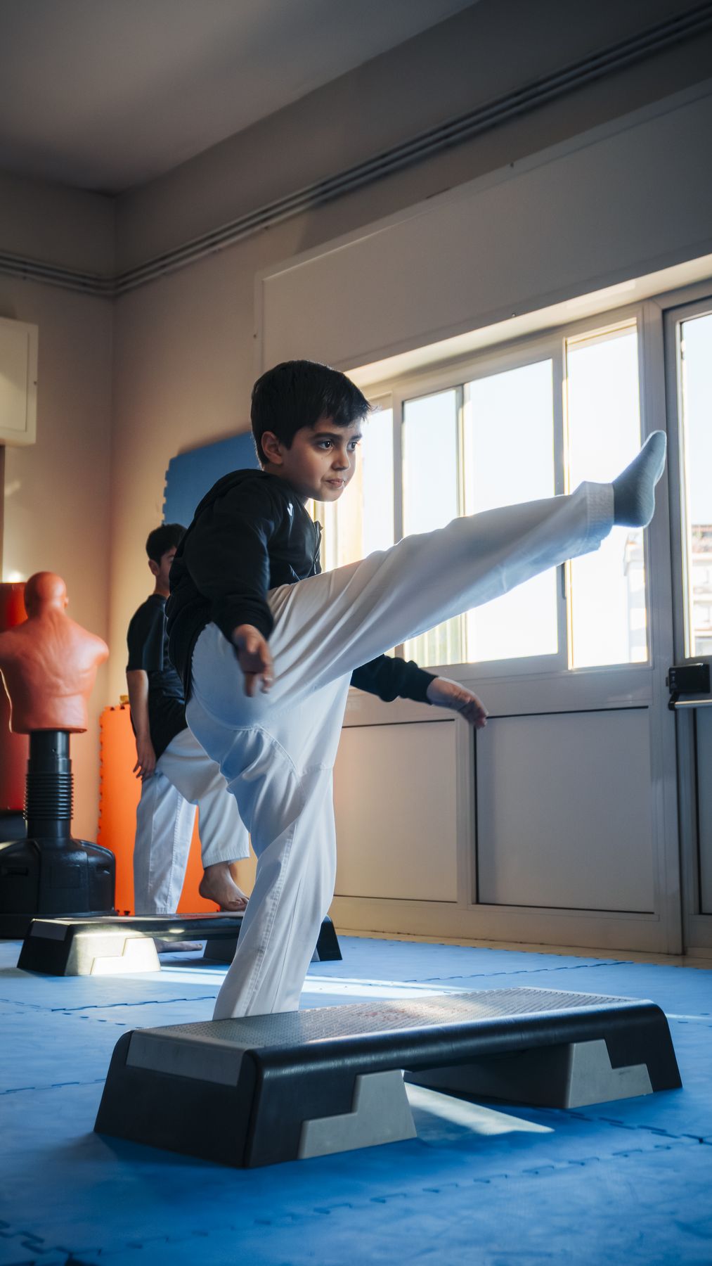 Un bambino esegue un calcio in equilibrio sullo step