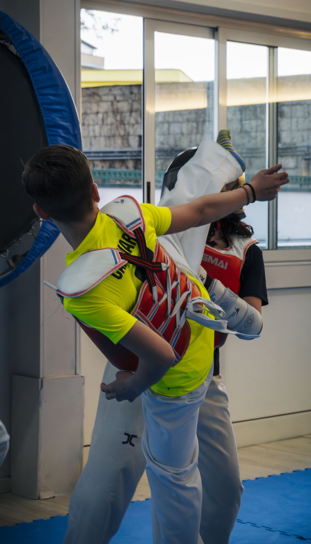 Un allievo con la corazza esegue un calcio girato durante lo sparring